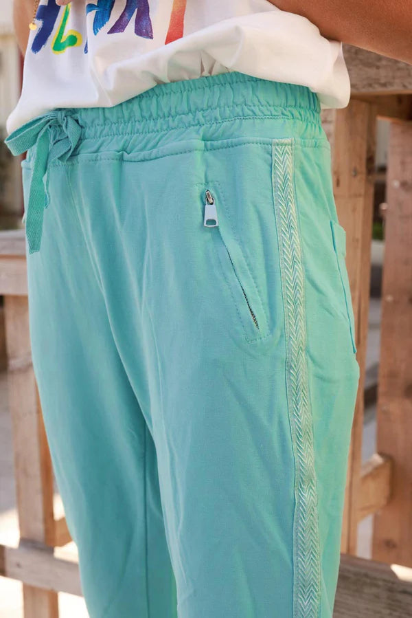 Turquoise cotton jogging bottoms with embroidered cheveron outseams